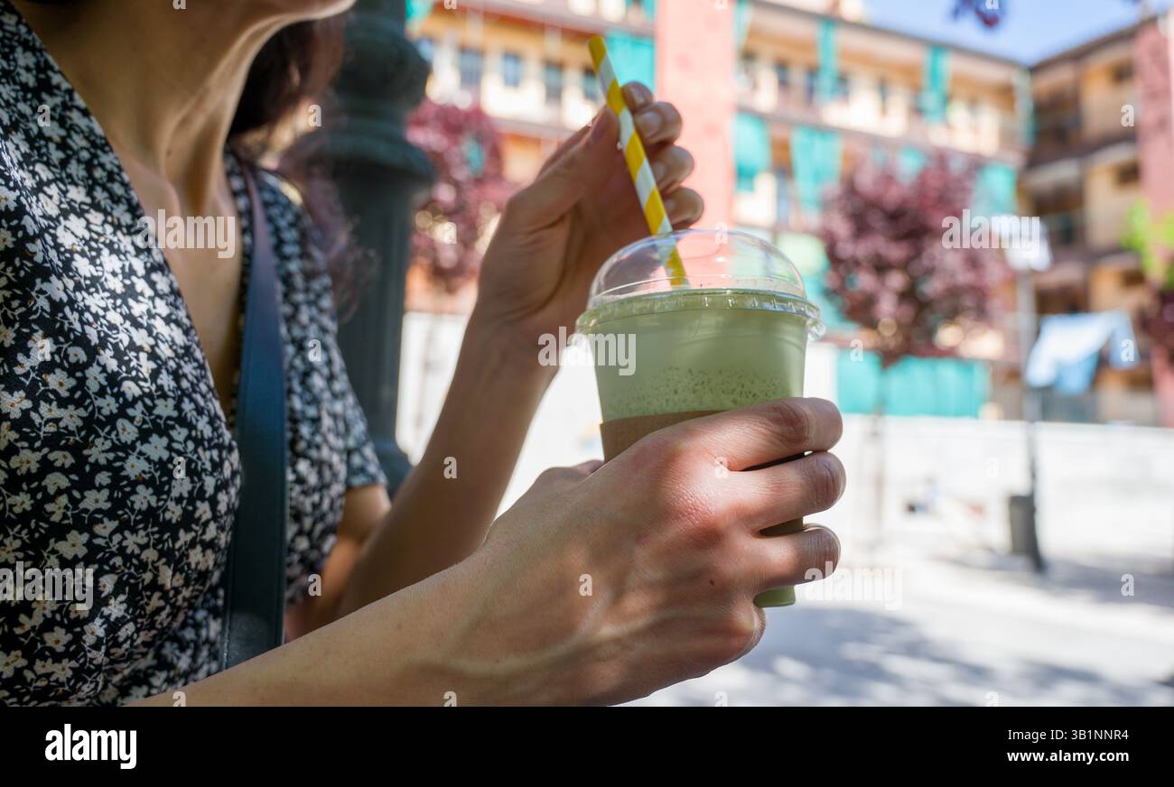 woman having iced matcha latte Stock Photo