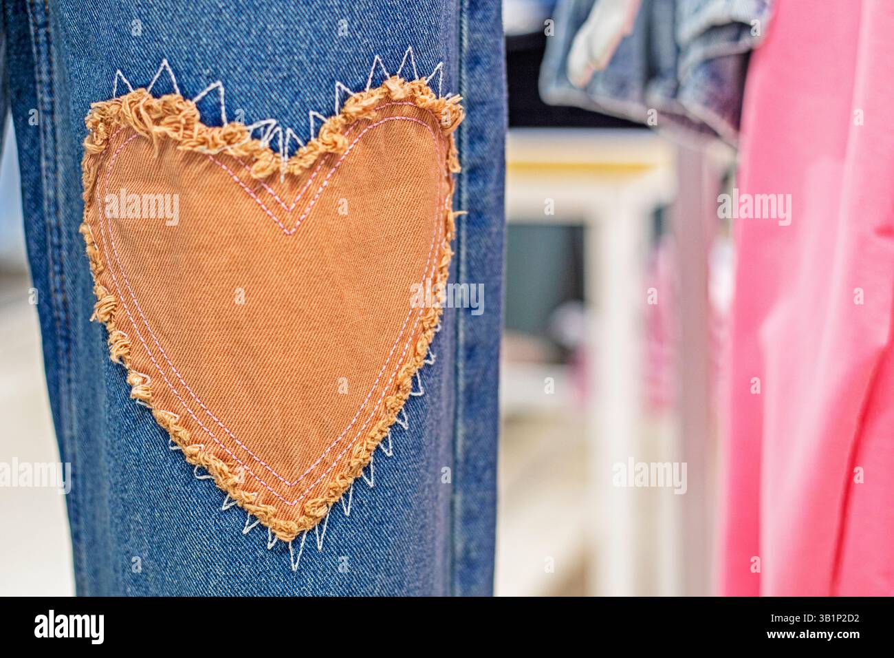 stylish jeans close-up with a patch in the form of a heart. Fashion and style Stock Photo