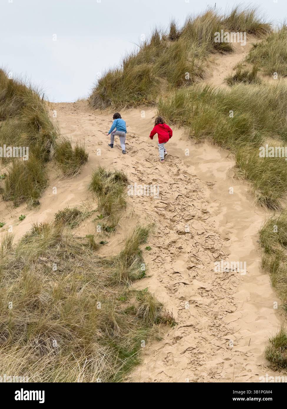 Children climbing sand dune in Formby Merseyside, - Smartphone Captured Stock Image