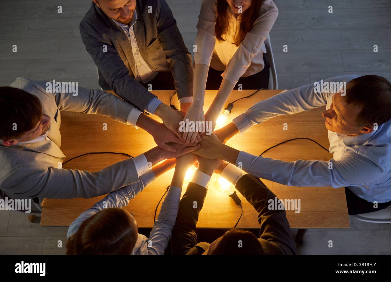Business people meeting for collaboration, keeping hands together over light bulbs Stock Photo