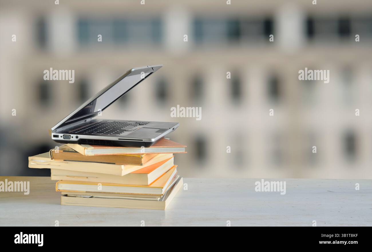 Laptop computer and stack of books Stock Photo - Alamy