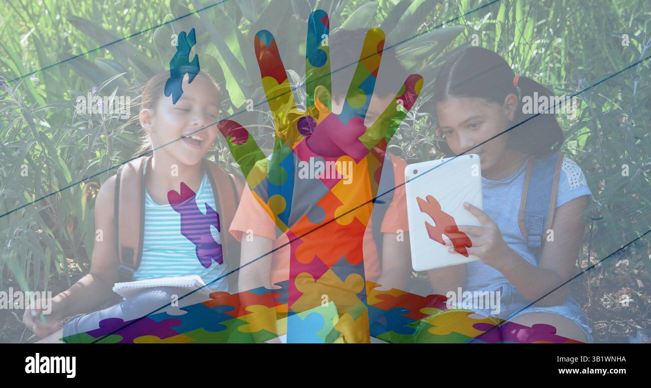 Image of colourful puzzle pieces hand over school children using tablets Stock Photo