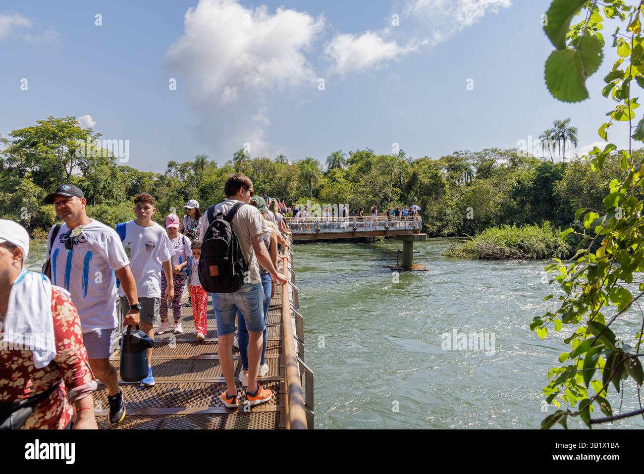 Puerto Iguazu, Misiones, Argentina - April 5th, 2025: Tourists trucking along the Iguazu Falls walkways. Stock Photo