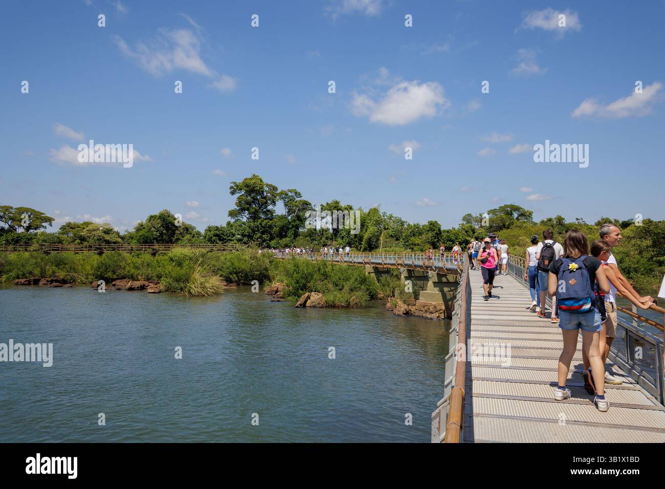 Puerto Iguazu, Misiones, Argentina - April 5th, 2025: Tourists trucking along the Iguazu National Park walkways. Stock Photo