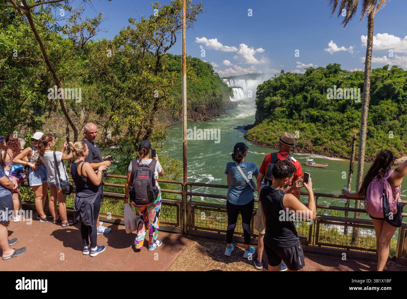 Puerto Iguazu, Misiones, Argentina - April 5th, 2025: Tourists watching Iguazu Falls from the lower circuit in Argentina. Stock Photo