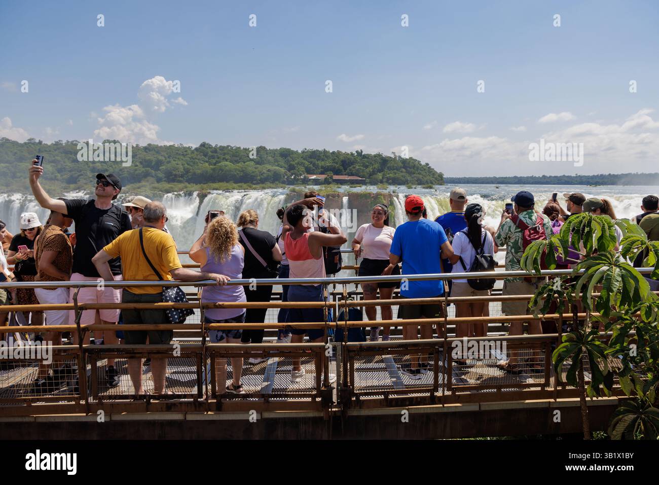 Puerto Iguazu, Misiones, Argentina - April 5th, 2025: Tourists watching the Devil's Throat waterfall at Iguazu Falls. Stock Photo