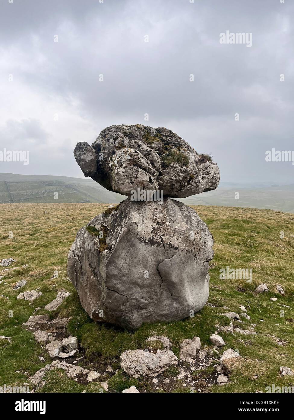 A balanced rock sits on an erratic boulder on the site of Lee Gate High Mark on Kilnsey moor in the Yorkshire Dales National Park - Smartphone Captured Stock Image