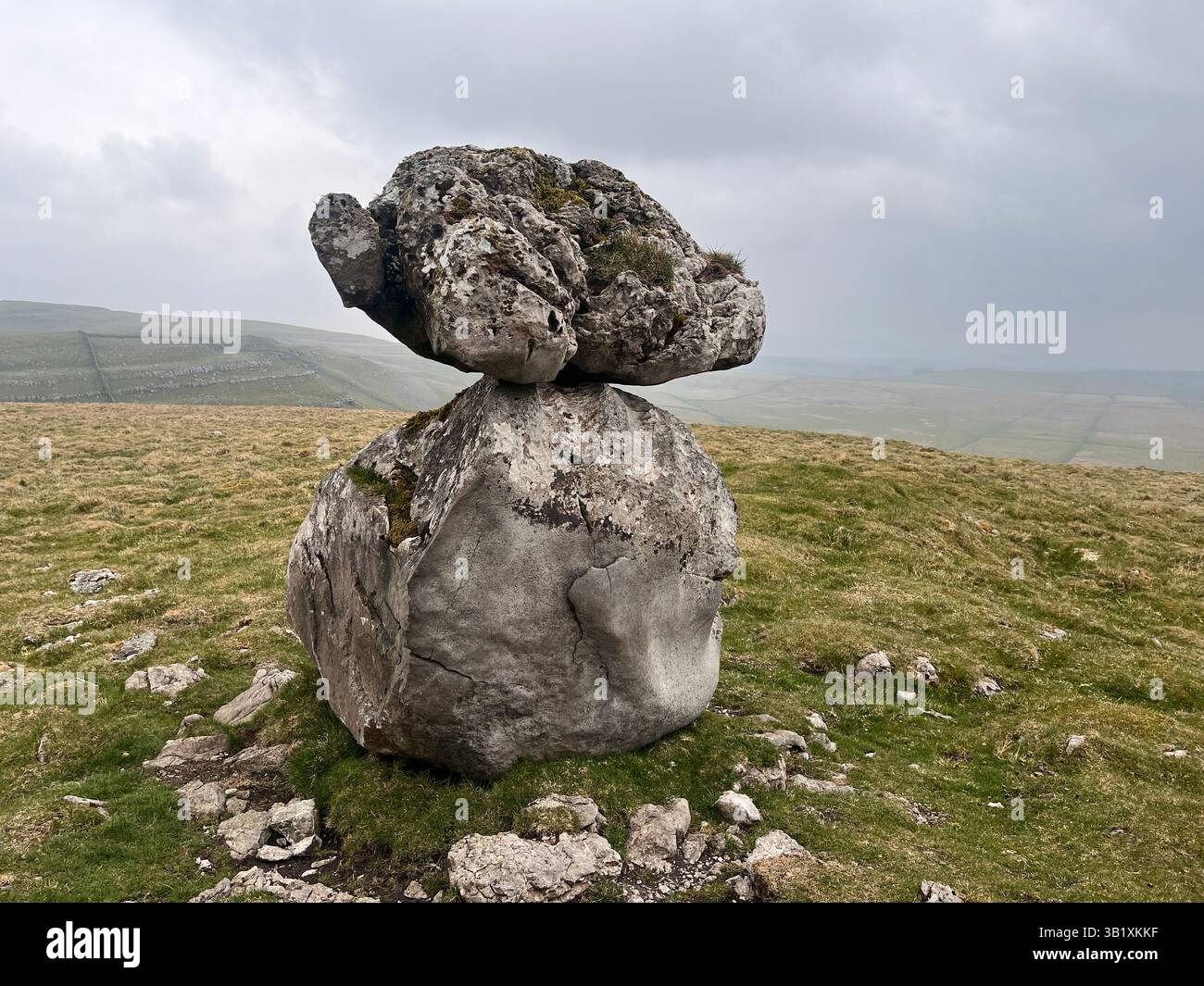 A balanced rock sits on an erratic boulder on the site of Lee Gate High Mark on Kilnsey moor in the Yorkshire Dales National Park - Smartphone Captured Stock Image