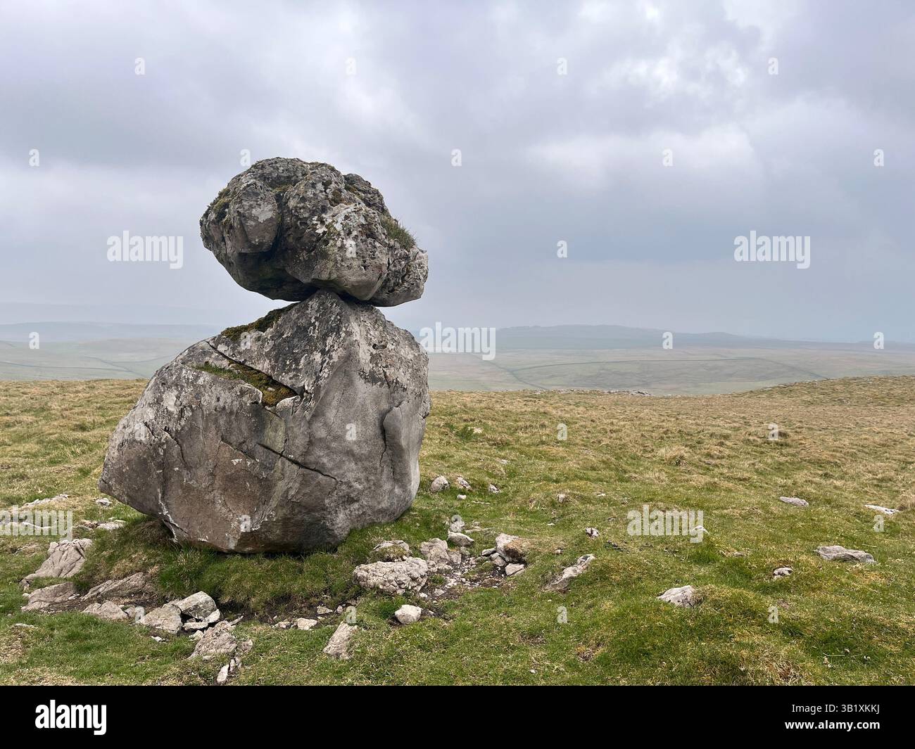 A balanced rock sits on an erratic boulder on the site of Lee Gate High Mark on Kilnsey moor in the Yorkshire Dales National Park - Smartphone Captured Stock Image