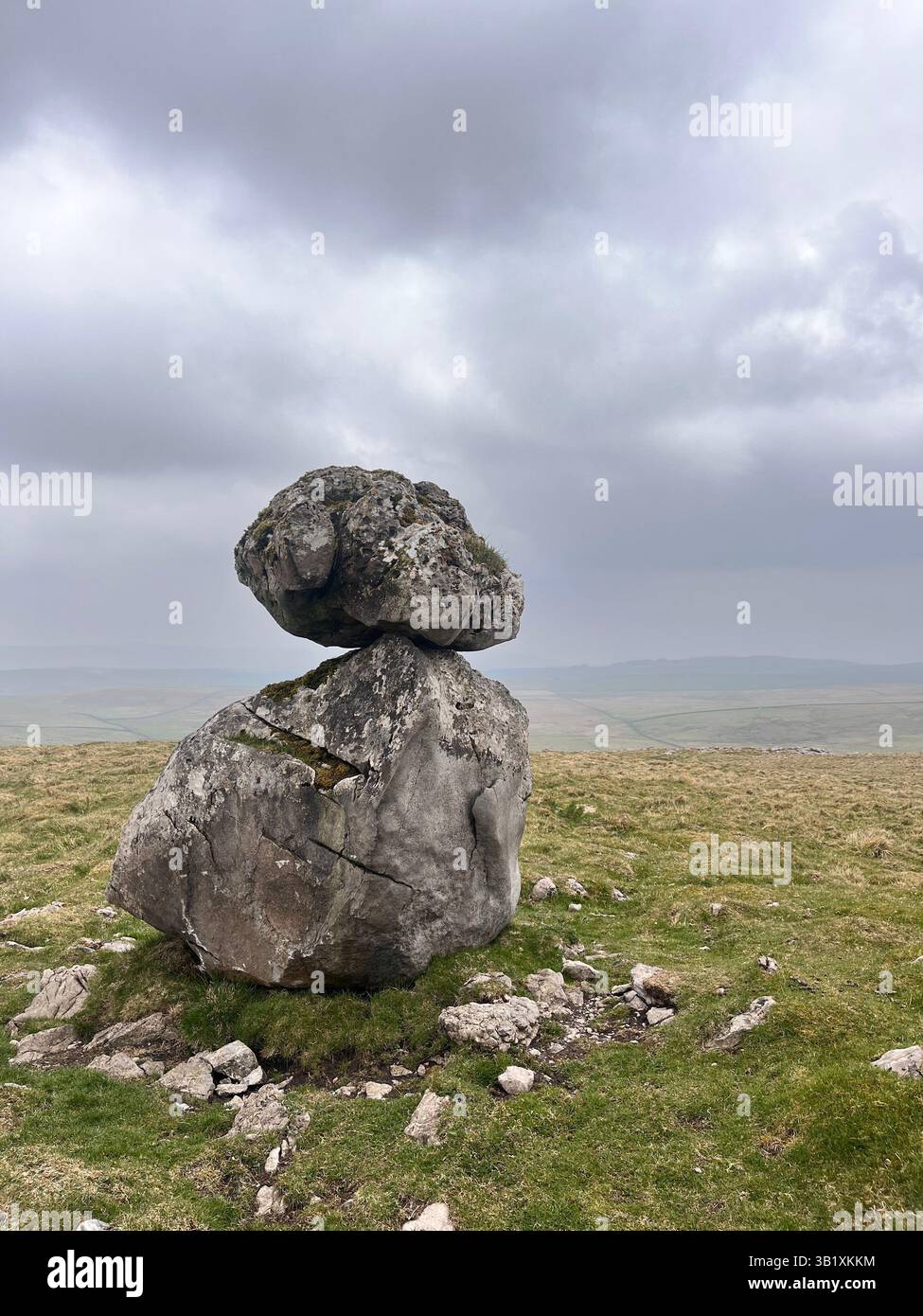 A balanced rock sits on an erratic boulder on the site of Lee Gate High Mark on Kilnsey moor in the Yorkshire Dales National Park - Smartphone Captured Stock Image