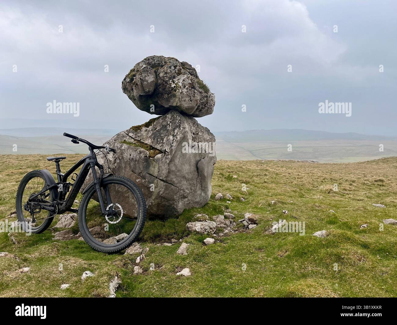 A balanced rock sits on an erratic boulder on the site of Lee Gate High Mark on Kilnsey moor in the Yorkshire Dales National Park - Smartphone Captured Stock Image