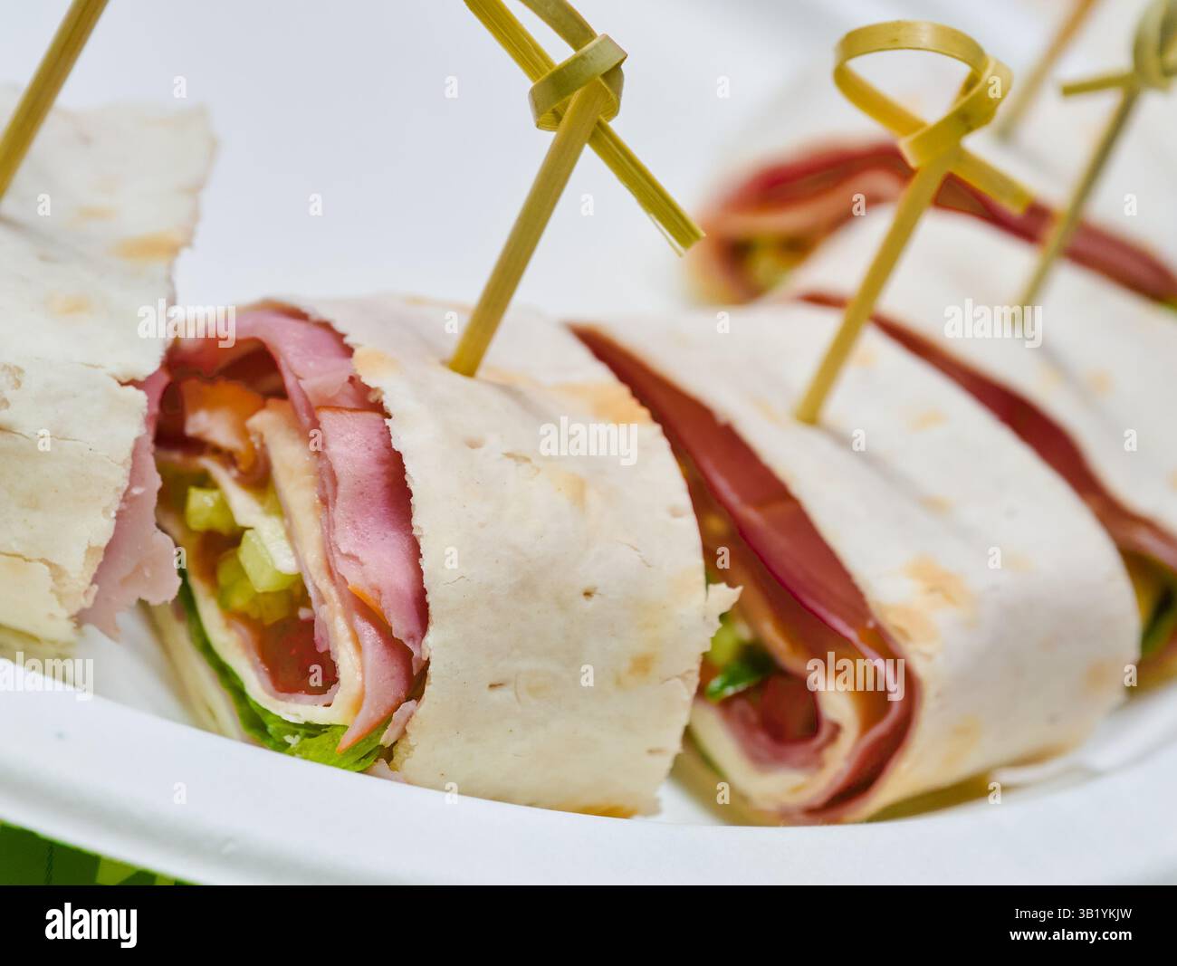 Delicious savory wraps filled with fresh ingredients and tasty meats at a vibrant outdoor gathering under the sun Stock Photo