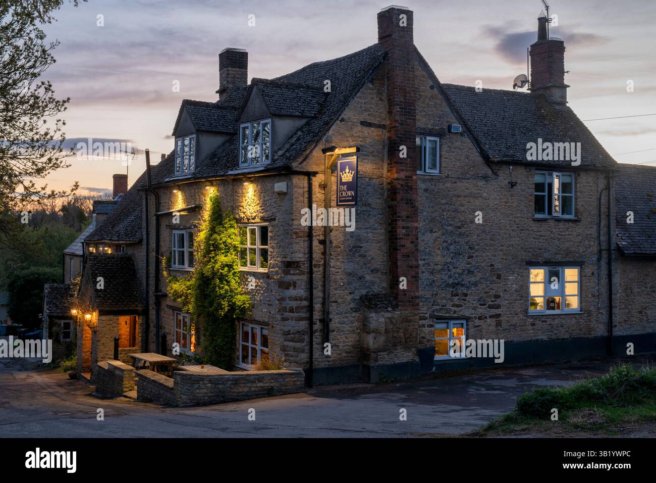 The Crown pub at dusk in spring. Church Enstone, Cotswolds, Oxfordshire, England Stock Photo