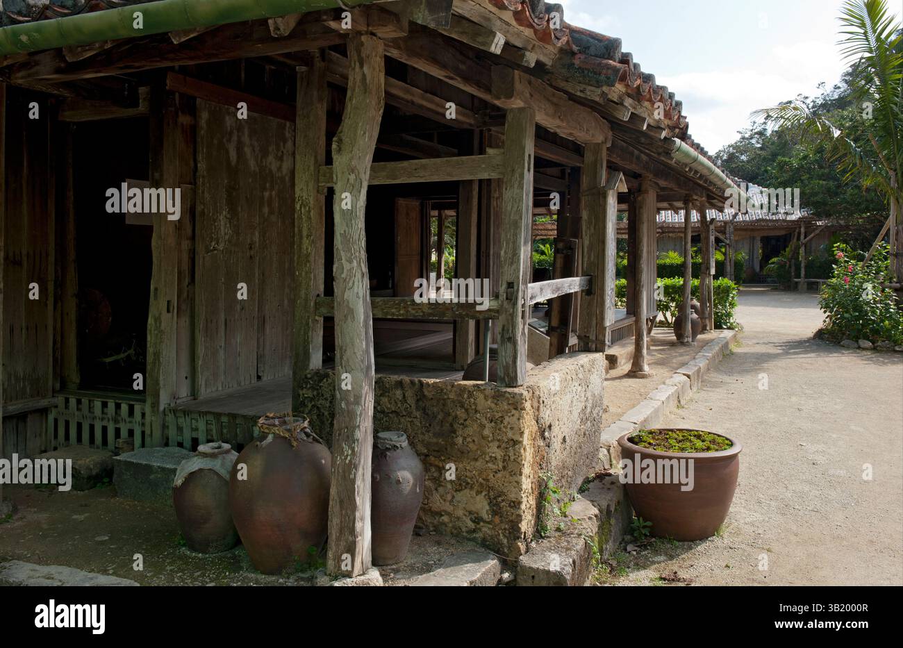 Traditional Okinawan historical residence with ceramic roof tiles and broad overhangs at the Ryukyu open air museum in Okinawa, Japan. Stock Photo