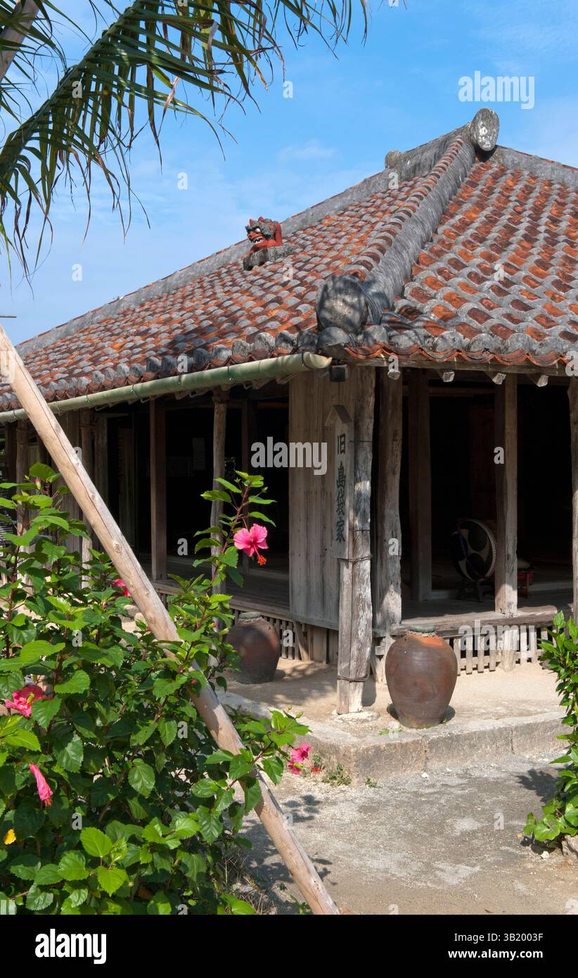 Traditional Okinawan historical residence with ceramic roof tiles and broad overhangs at the Ryukyu open air museum in Okinawa, Japan. Stock Photo