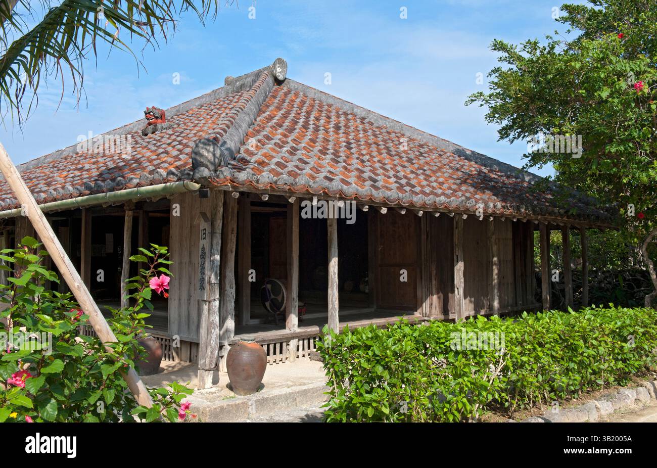 Traditional Okinawan historical residence with ceramic roof tiles and broad overhangs at the Ryukyu open air museum in Okinawa, Japan. Stock Photo