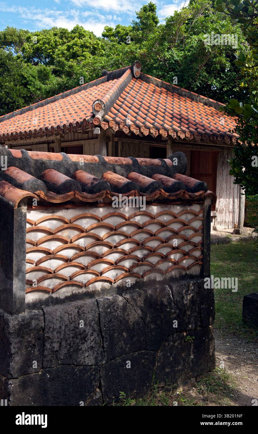 Okinawan residence wall has a wave-like pattern created with used roof tiles seen at the Native Okinawan Village in Ocean Expo Park, Okinawa, Japan. Stock Photo