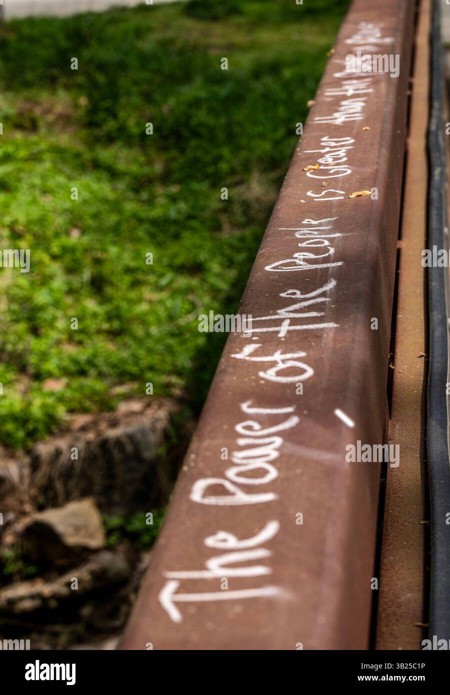 A slogan chalked on the rail of a bridge Stock Photo