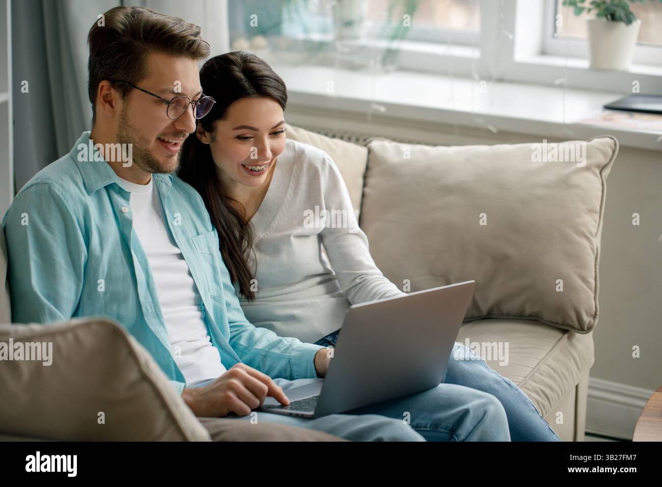 Happy Couple Using Laptop at Home Stock Photo