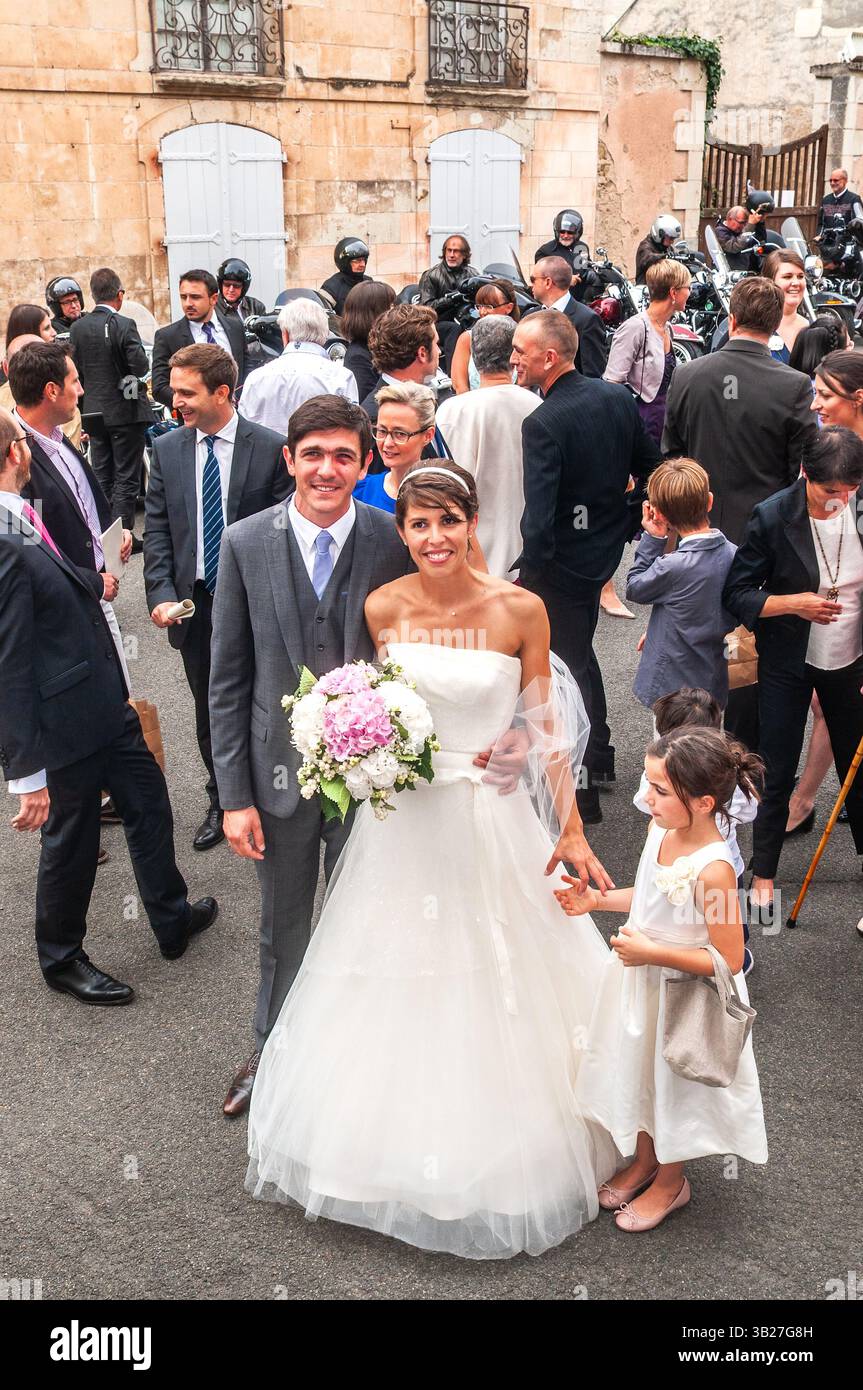 Married couple and wedding party after legal civil ceremony before church for second ceremony - Preuilly-sur-Claise, Indre-et-Loire (37), France. Stock Photo