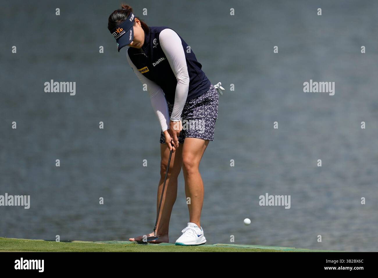 In Gee Chun, of South Korea, putts with one shoe on the third green