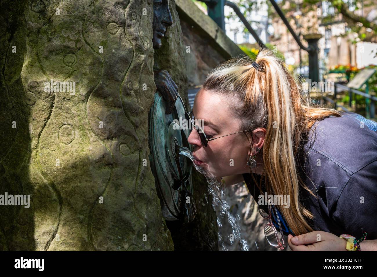 A person drinking from the Malvhina fountain, Great Malvern, Worcestershire, UK. 2025 Stock Photo