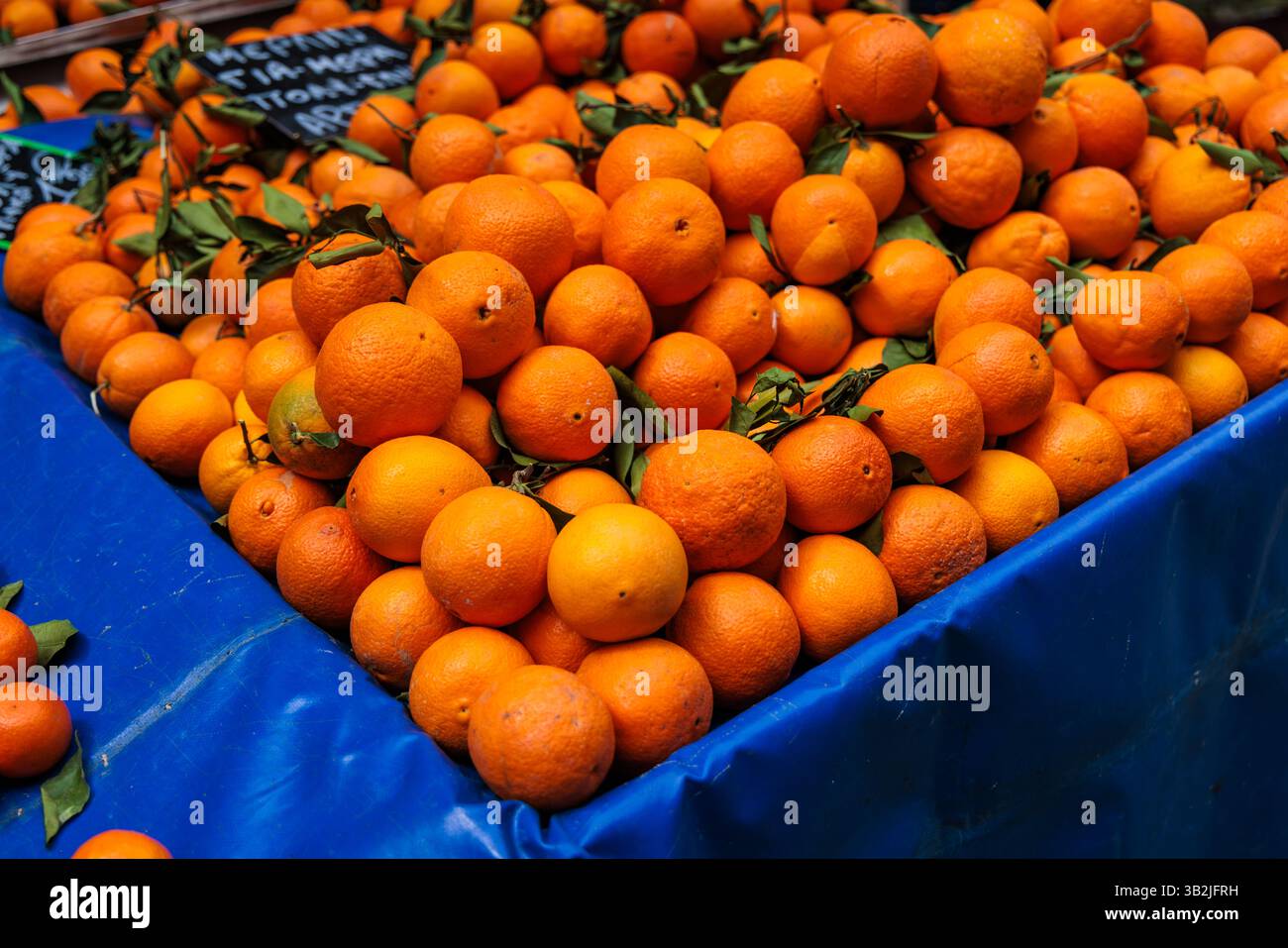 Oranges piled up for sale at the Kallidromiou farmers market in Exarchia, Athens, Greece. Stock Photo