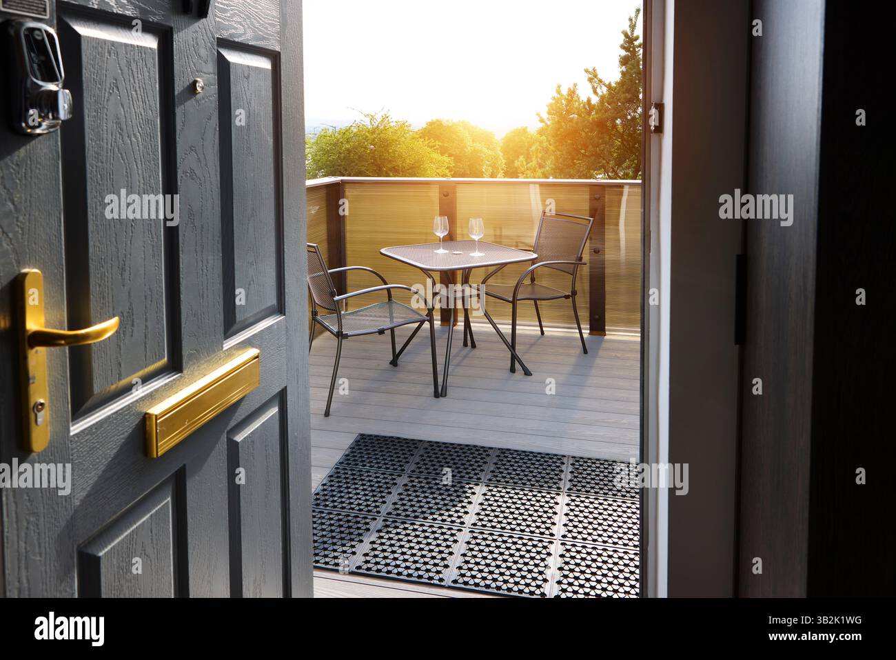 Modern, balcony and door at hotel with chairs, table and wine glass ...