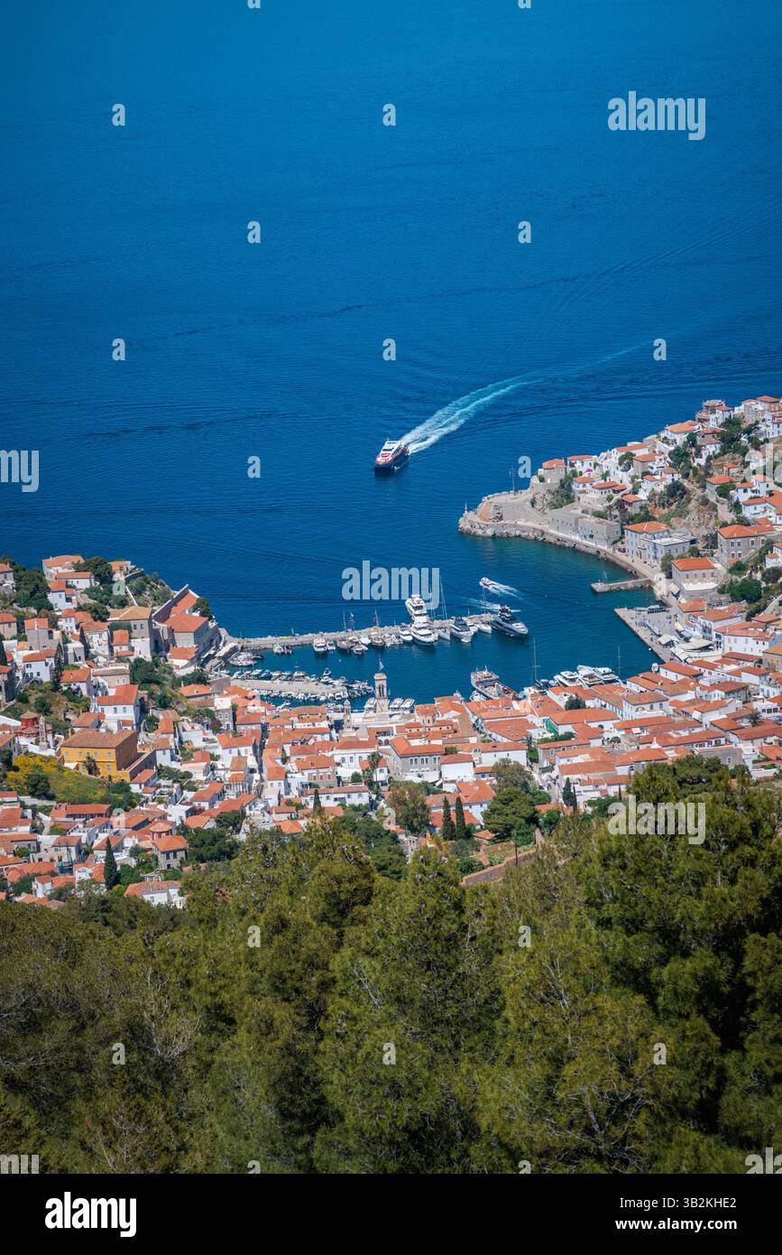 Aerial view of the main harbour on Hydra island in Greece, with red-roofed houses clustered around the port. Stock Photo
