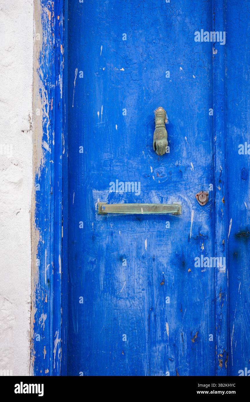 Close-up of painted blue door alongside a whitewashed wall on the island of Hydra, Greece. Stock Photo