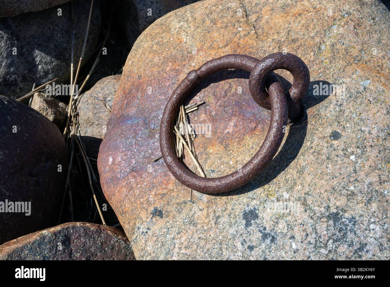 rusty old mooring ring on shore Stock Photo