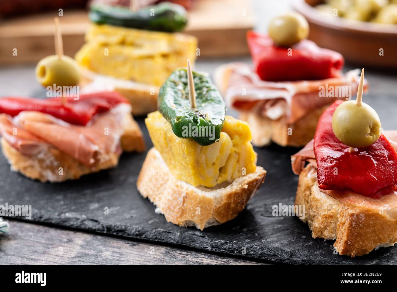 Traditional Spanish pintxos on wooden table Stock Photo