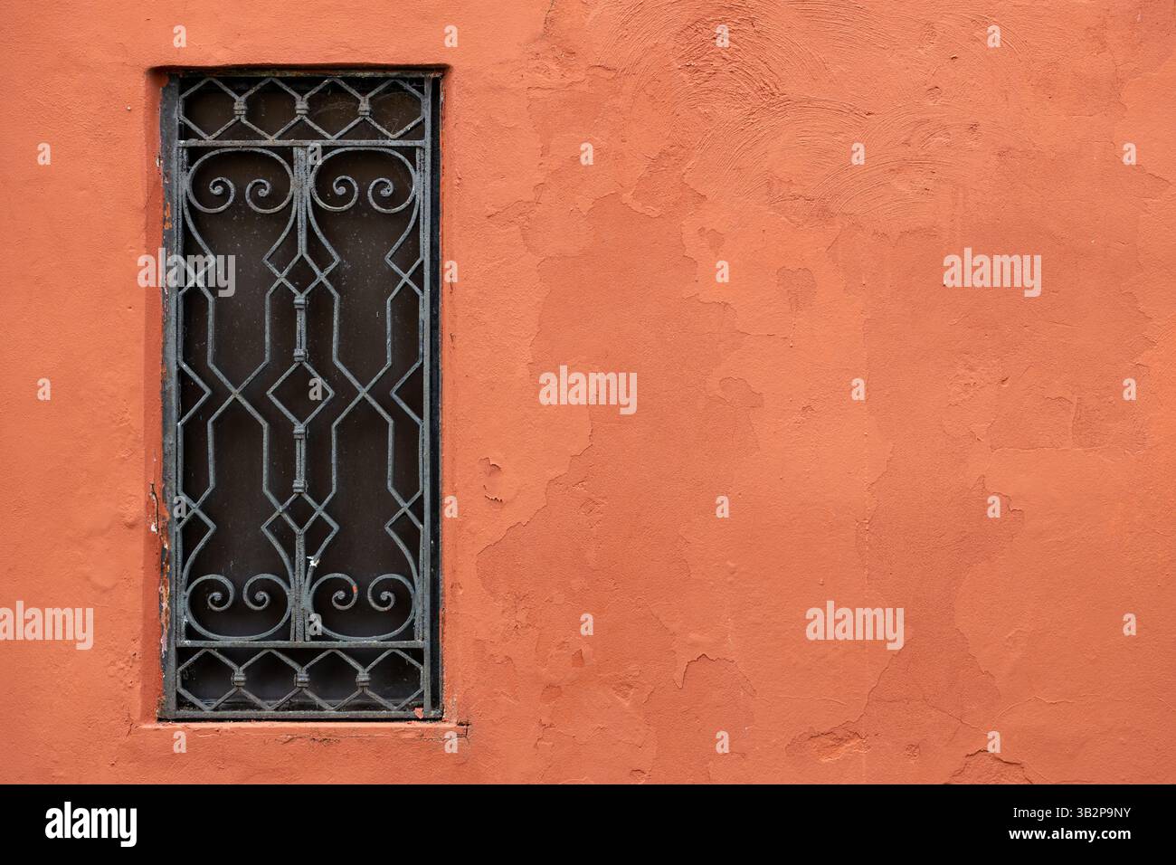 Decorative iron window on terracotta wall Stock Photo