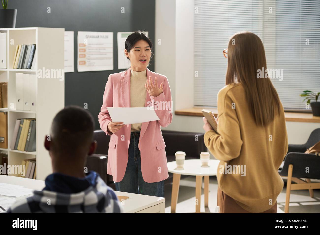 Asian Woman Explaining Language Concepts in Classroom Stock Photo