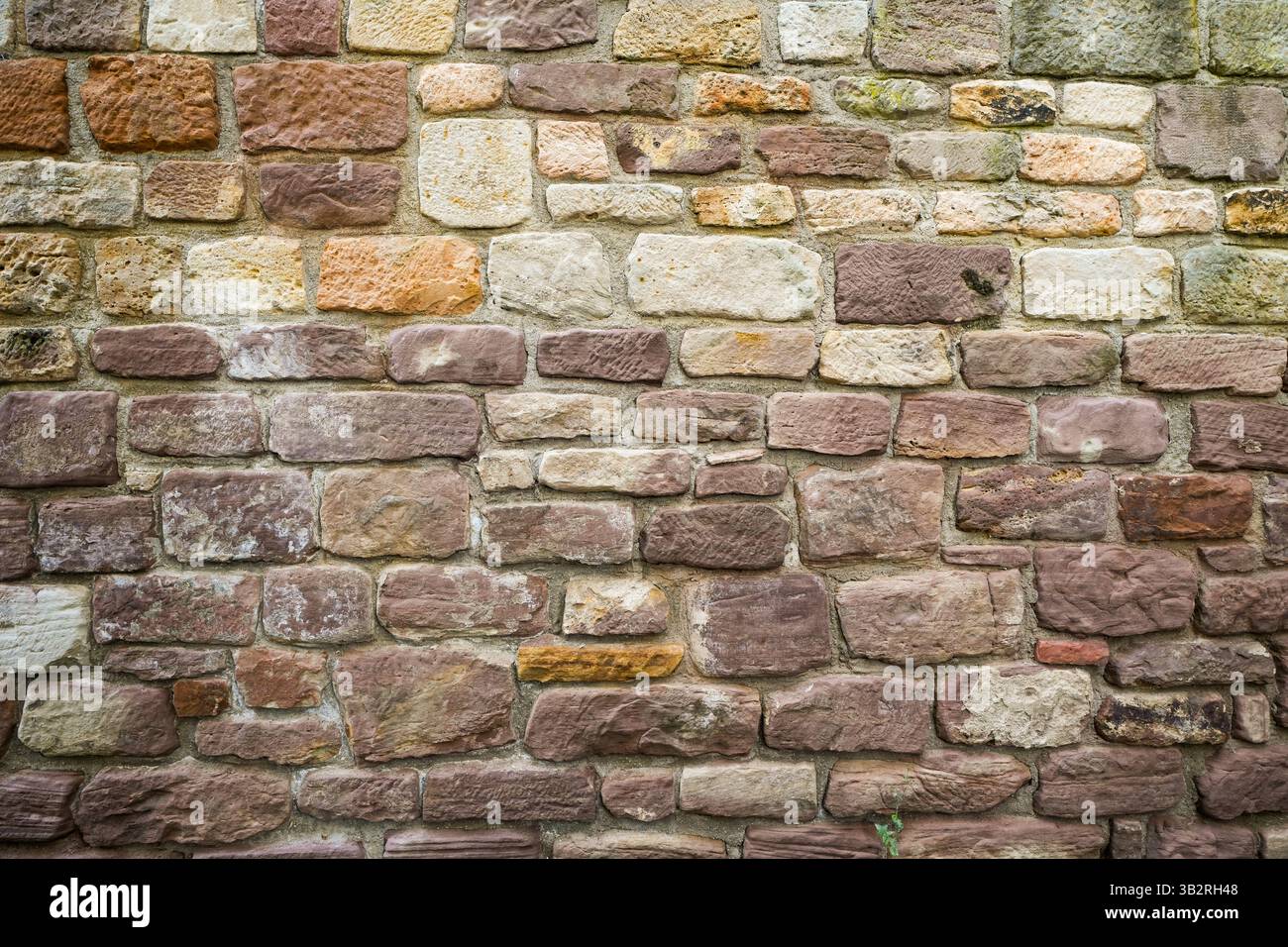 Old rustic wall made of brown stones. Stock Photo