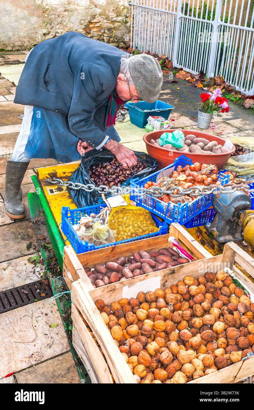 Local man laying out his fresh vegetables and nuts for sale on market day - Preuilly-sur-Claise, Indre-et-Loire (37), France. Stock Photo