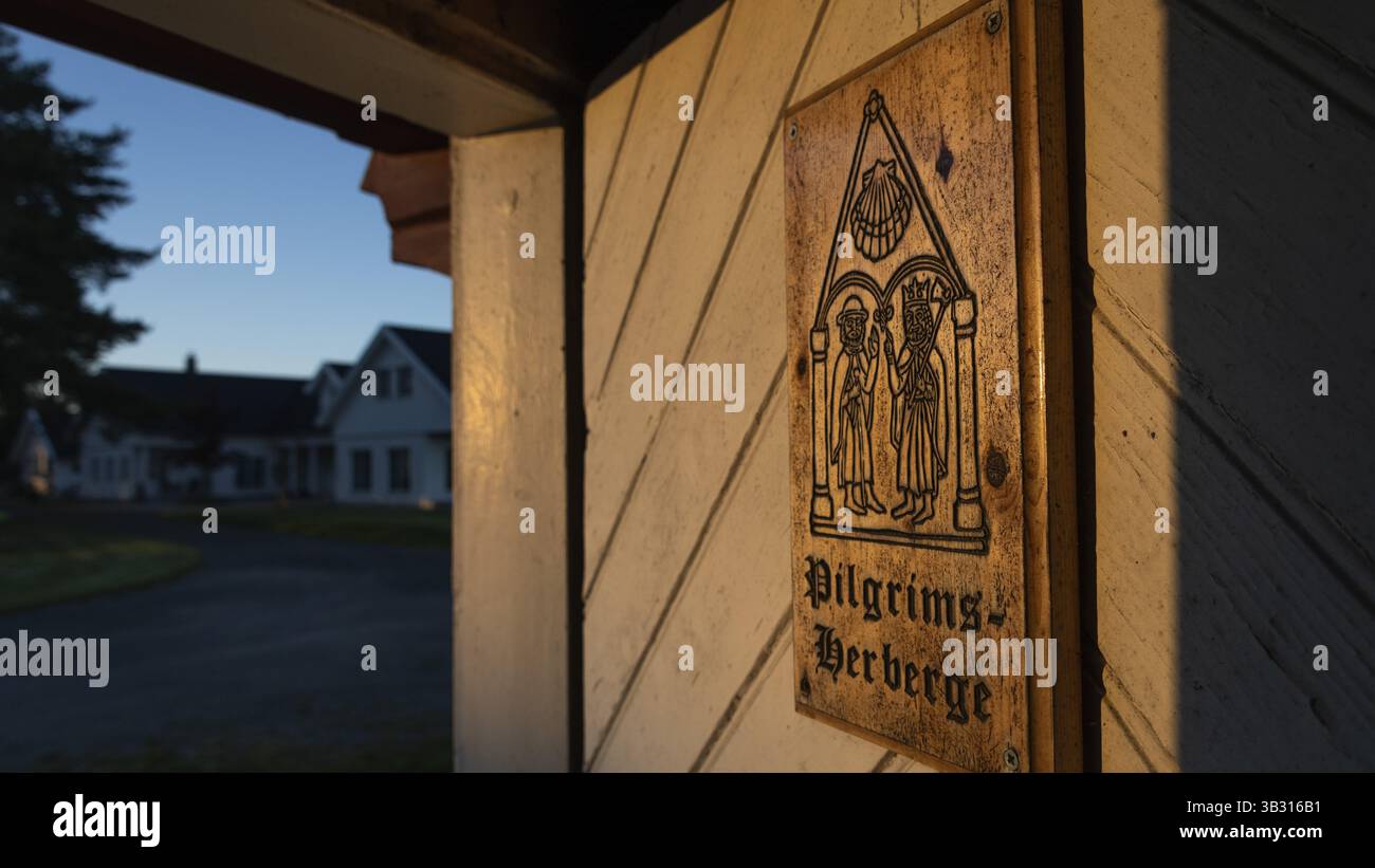 Pilgrims and Olav the Saint or Olav II Haraldsson with axe, Pilgrims Hostel lettering, wooden plaque on door with engraving, on a wooden door, Pilgrim Stock Photo