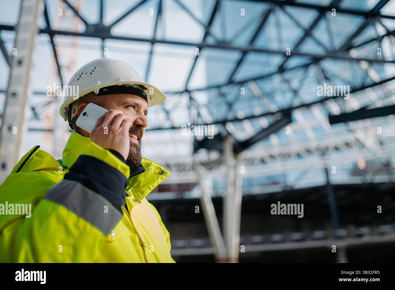 Construction site manager making phone call while inspecting building site. Stock Photo