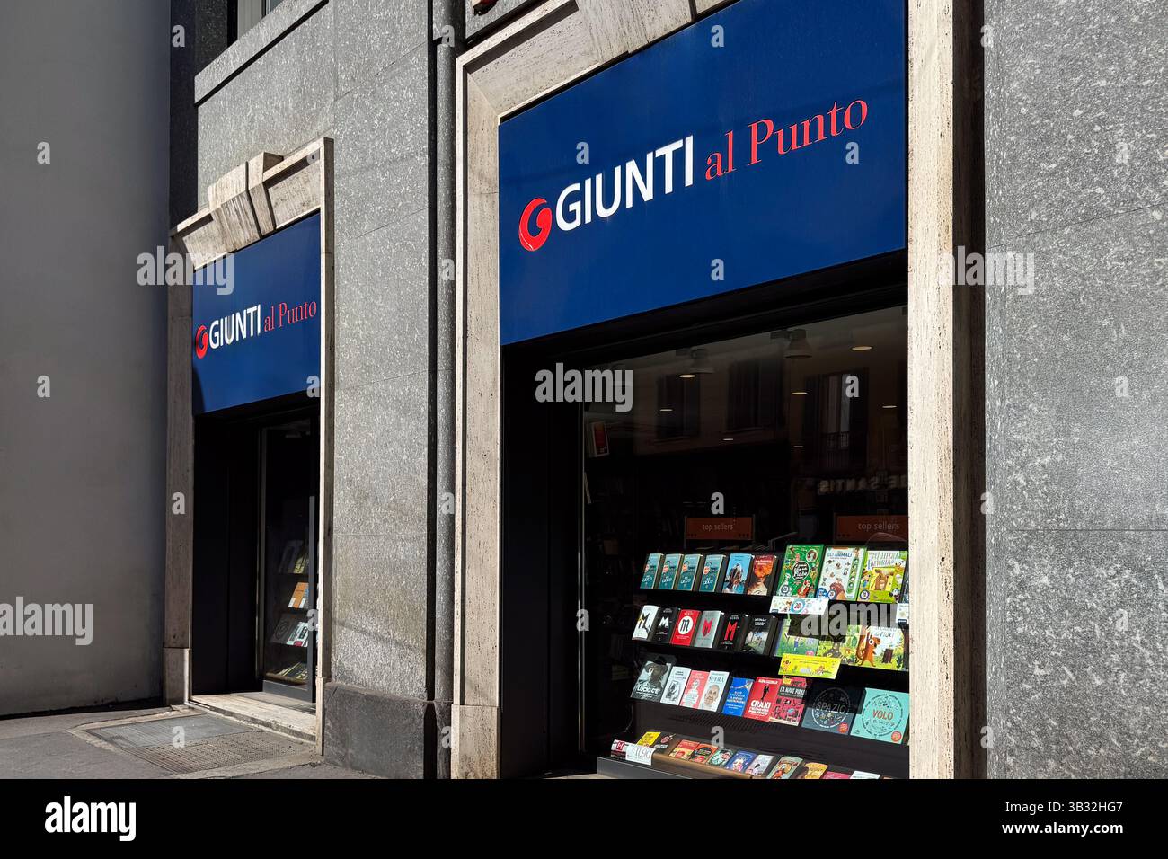 Milan, Italy - April, 11, 2025: Giunti al Punto bookstore with window full of bestsellers and children books. Sunny urban street scene Stock Photo