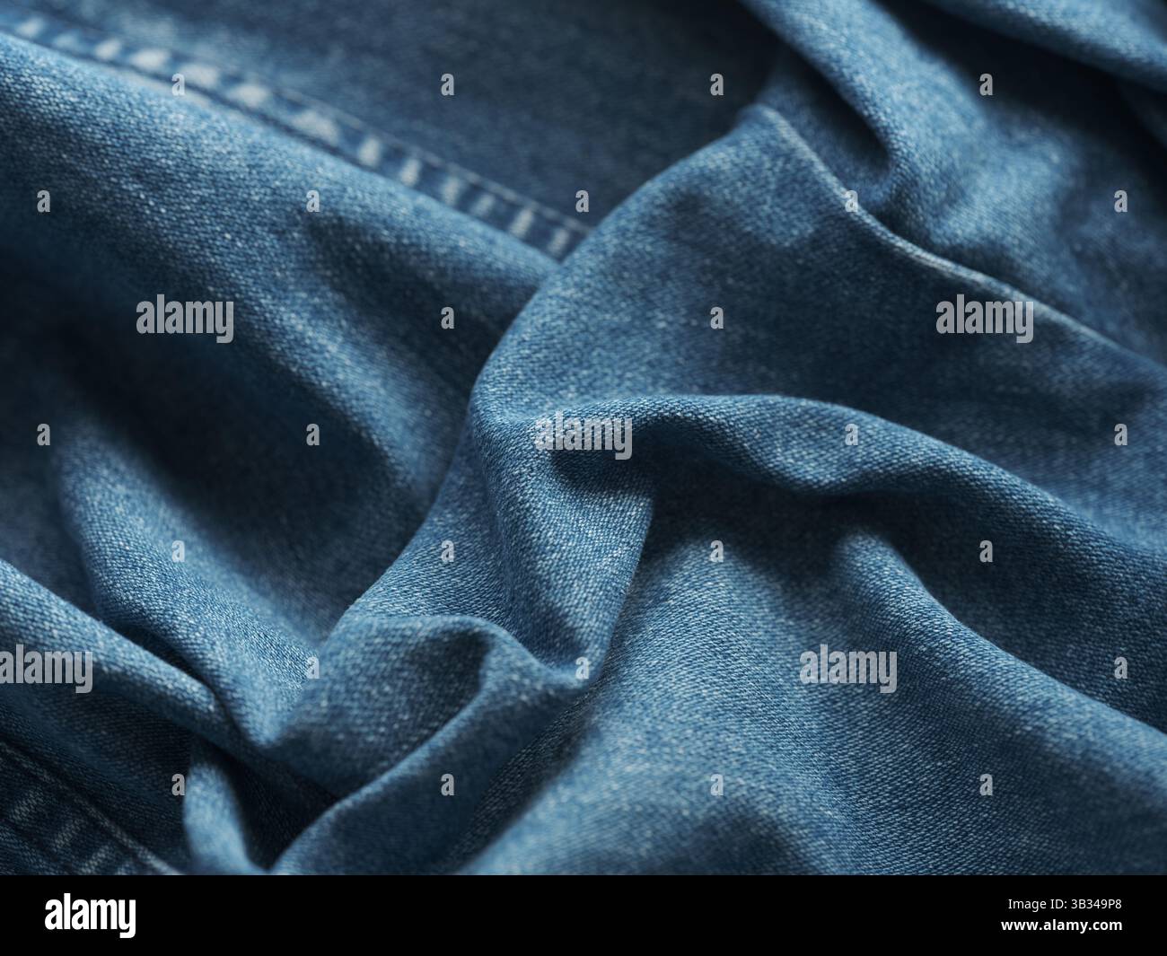 A background of blue wrinkled denim jeans. Close up. Stock Photo