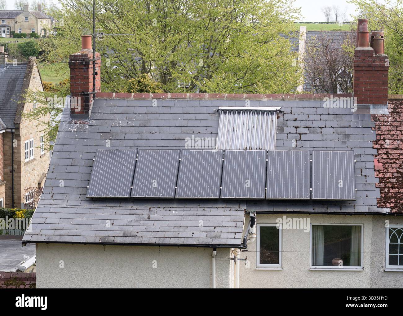 House roof with both thermal and  photovoltaic solar panels, England, UK Stock Photo