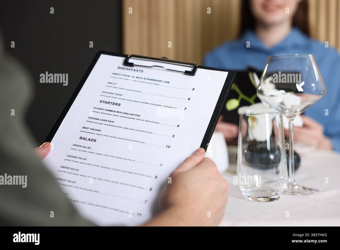 Couple choosing dishes from menu at table in restaurant, closeup Stock ...