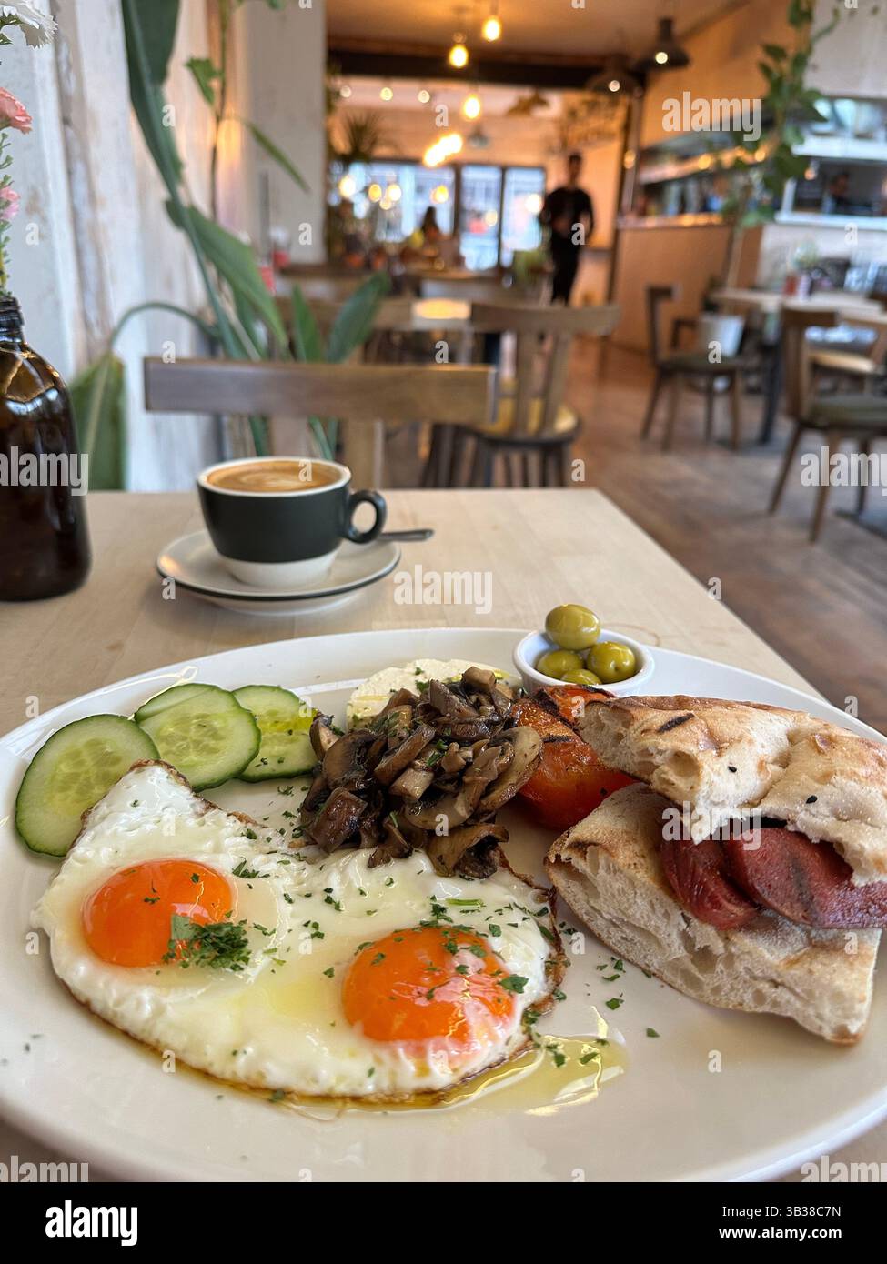 A traditional Turkish breakfast served with coffee on a wooden table in a quiet, calm cafe in London, England. - Smartphone Captured Stock Image