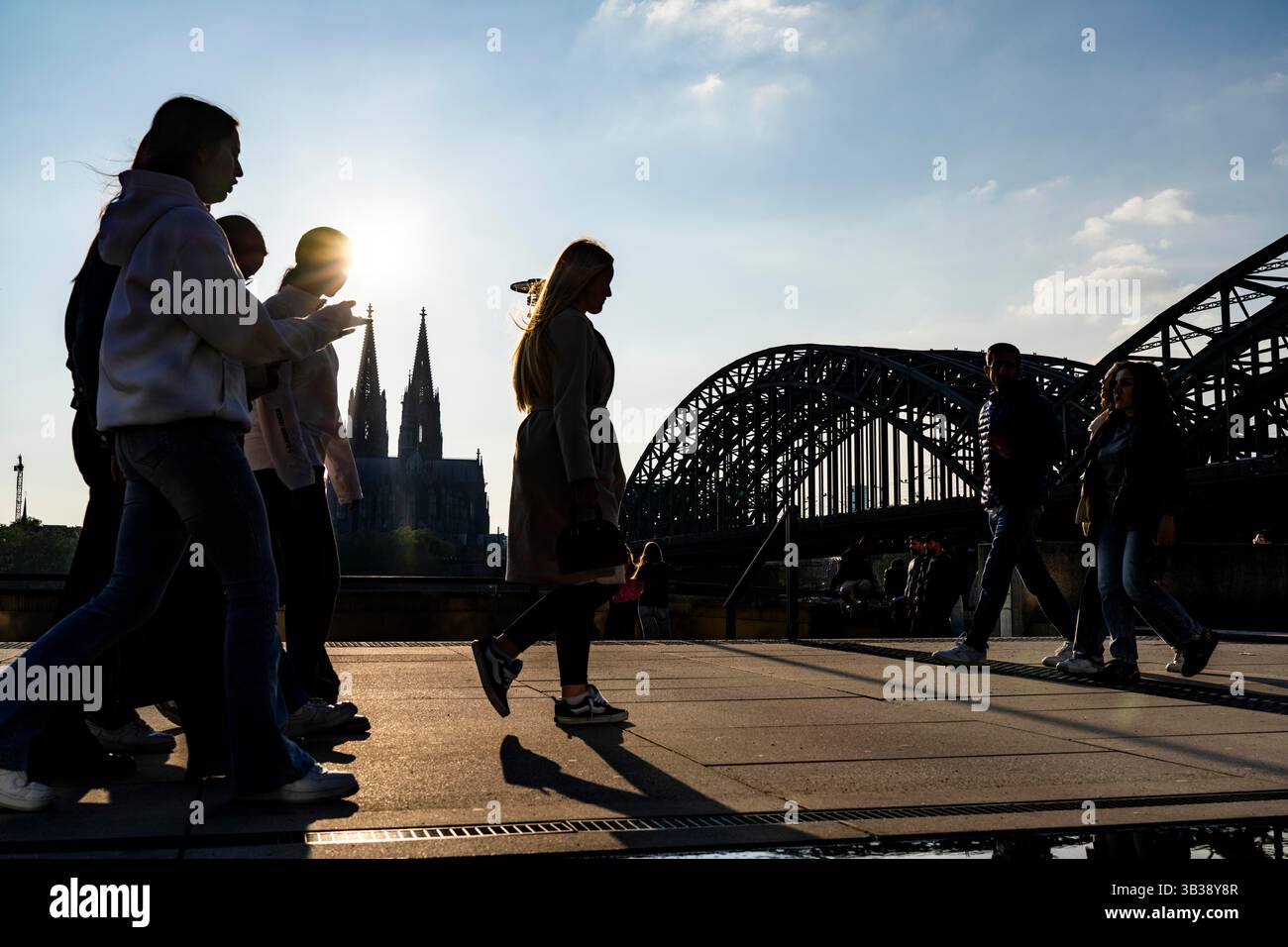 Silhouettes of people in the late afternoon sunlight on the Deutz bank ...