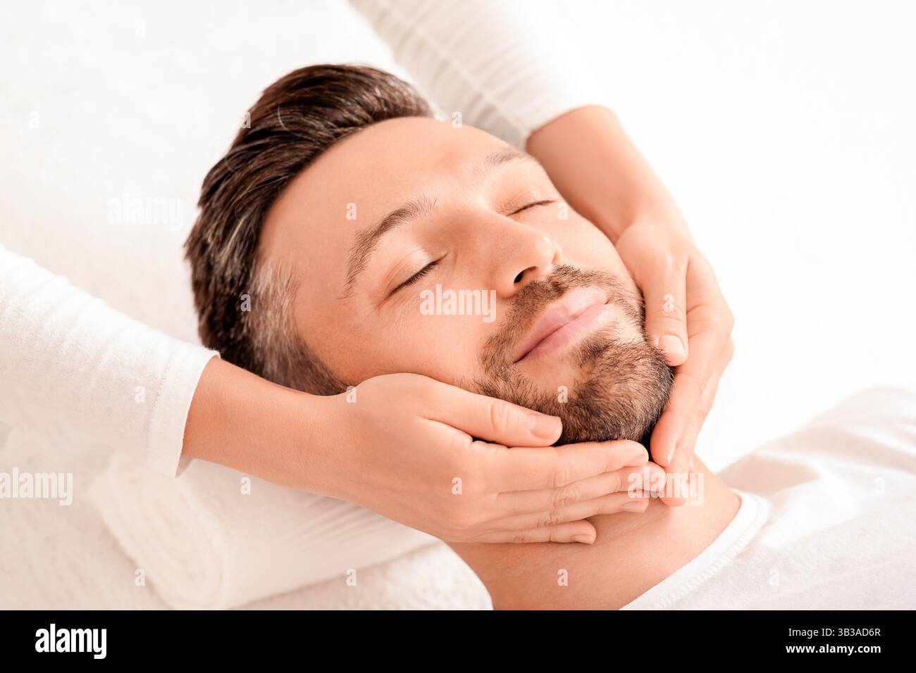 Spa therapist making relaxing massage for handsome man Stock Photo