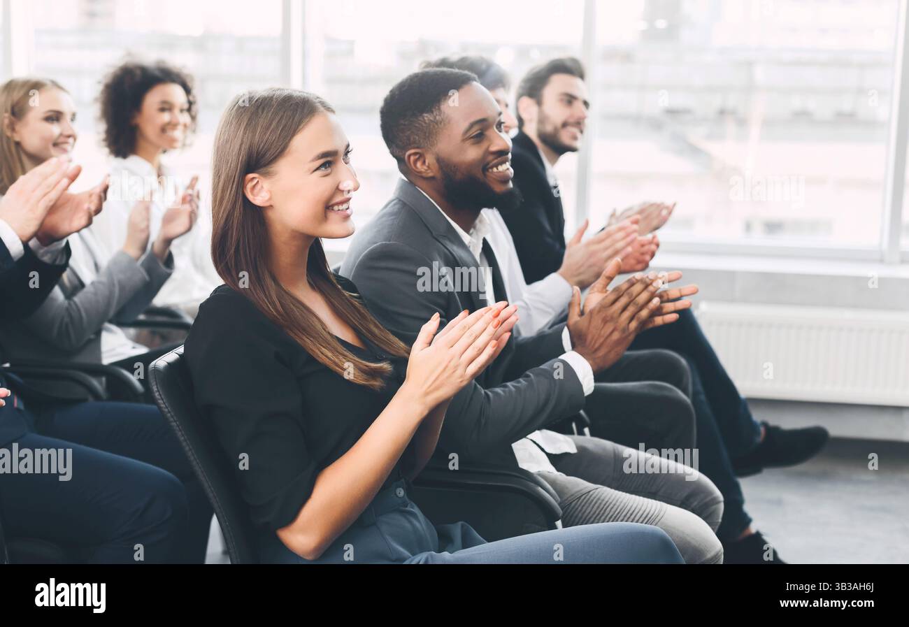 Diverse business team greeting speaker with applause Stock Photo