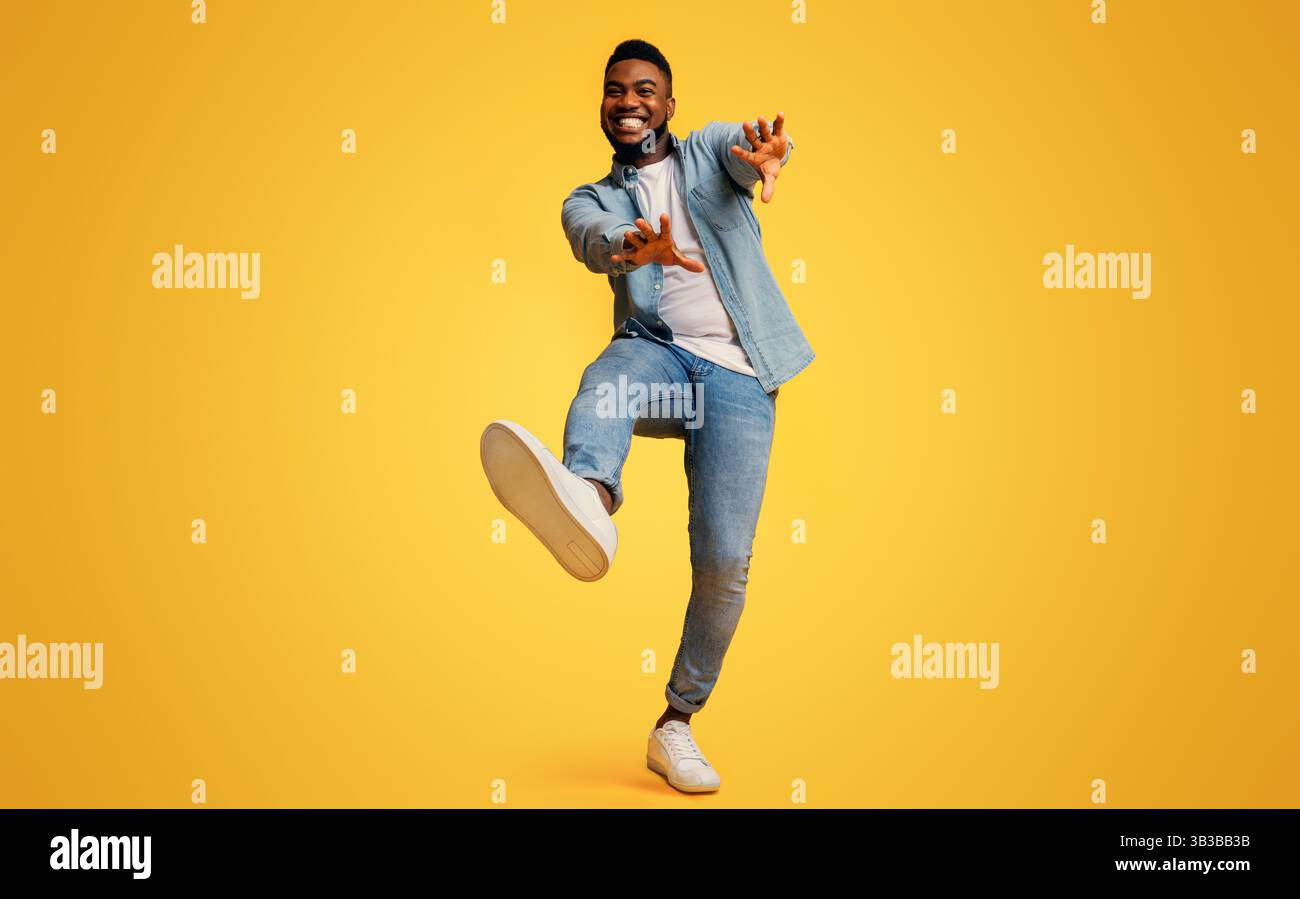 Funny black man dancing and extending his hands to camera Stock Photo