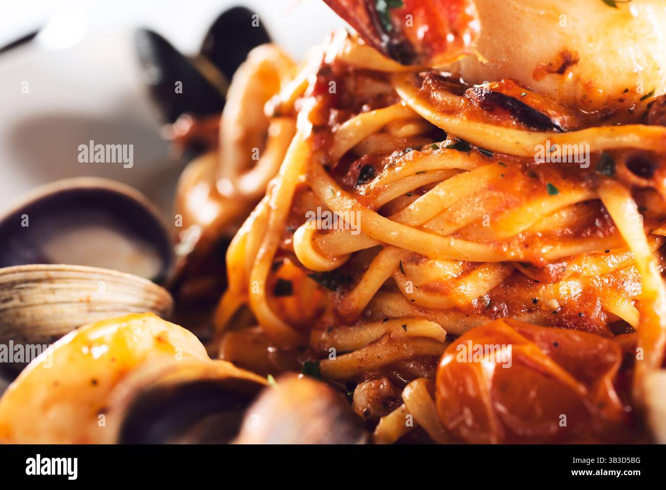 A closeup view of a twirl of tagliolini with an array of seafood. Stock Photo