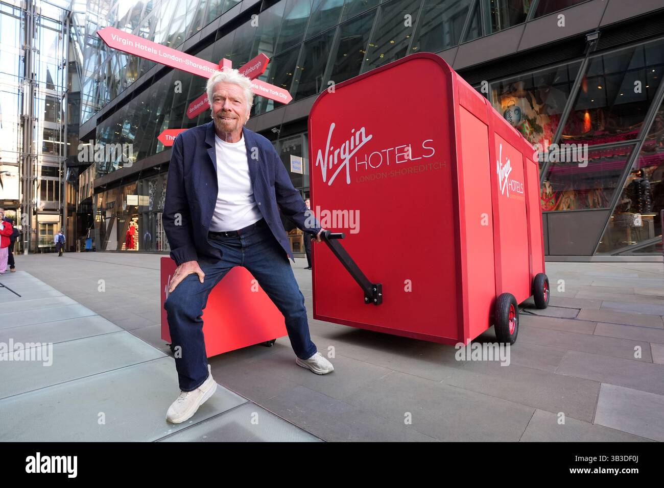 Sir richard branson with a giant virgin hotels branded red