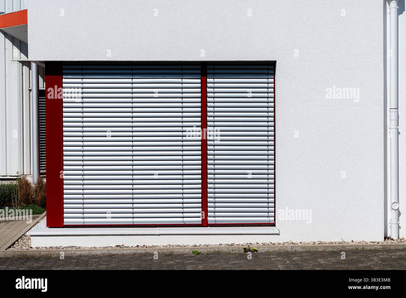 Closed aluminum blinds shield the windows of a contemporary building ...